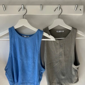 Två ribbade linnen från Zara - Säljer två ribbade linnen från Zara i storlek M. En i klarblå färg och en i gröngrå/militärgrön färg. De har rund halsringning och är relativt korta i modellen. De är knappt använda, och har inga fläckar eller märken!