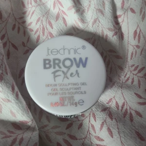 Technic Brow Fixer Brow Sculpting Gel - Technic Brow Fixer är en transparent bryngel i rund plastburk med vit lock. Perfekt för att forma och hålla brynen på plats hela dagen. Innehåller 14g gel som är lätt att applicera och ger ett naturligt resultat utan att kännas kladdig.