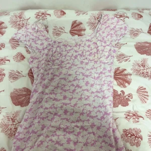 Ljuslila blommig kortklänning - Säljer en söt ljuslila kortklänning med vitt blommigt mönster. Köpt från primary I Tyskland.