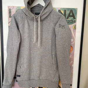 Robbie Moor hoodie - Snygg grå hoodie från Robbie Moor med broderad RM-logga på ärmen. Kom privat för fler frågor och funderingar:)