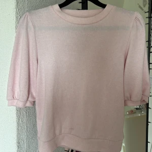 Ljusrosa stickad tröja från 157 - Supersöt ljusrosa stickad tröja från 157 med puffiga korta ärmar och rund halsringning. Tröjan har en mjuk känsla och är perfekt för vår och sommar. Enkel och stilren design som är lätt att matcha med jeans eller kjol. En liten liten fläck längst ner, men knappt något som syns!!💝