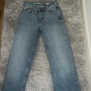 Blå mid wide jeans med raka ben - Säljer ett par blå jeans med midja i midwaist-modell och raka, lite bredare ben. Klassisk femficksdesign och snygg tvättad denim. Perfekta till sneakers eller boots för en chill look.