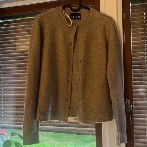Beige kofta från Pieces - Beige kofta från pieces med mysigt material☺️☺️ endast lite nopprig men inte något som är så märkbart!! Säljer då den inte kommer till användning 💓