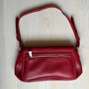 Röd axelväska från Björn Borg - Vinröd axelväska från Björn borg i mycket fint skick. Mycket utrymme med en innerficka och ytterficka. 