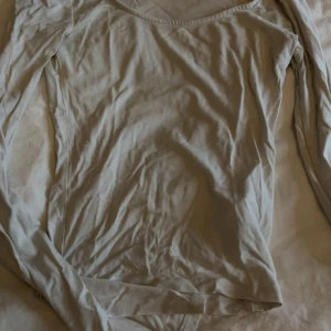 vit långärmad topp med u-ringning - en vit långärmad topp med u-ringad hals från ginatricot.