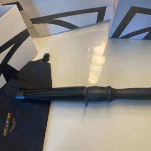 CeraWand locktång svart - Säljer en svart locktång från CeraWand med konformad stav och lång sladd. Perfekt för att skapa snygga lockar och vågor. Handtaget är ergonomiskt och tången har en stilren, matt finish. Pris kan diskuteras❣️