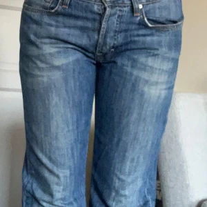 Blå jeans från Hugo Boss Regular Fit - Snygga blå jeans från Hugo Boss i modellen Regular Fit.  orangea sömmar och knappgylf.