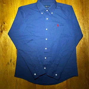 Blå Raffe skjorta herr - Schysst blå raffeskjorta i princip aldrig använd och mycket bra skick. Något liten i passformen och i storlek M. Vid funderingar är det bara att fråga jag är ärlig och rak med svar😁.