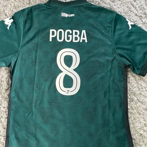 AS Monaco Borta 25/26 Pogba - Monaco borta 25/26 med Pogba på ryggen. Tags kvar och helt oanvänd då den inte passade. Stl L men sitter som M