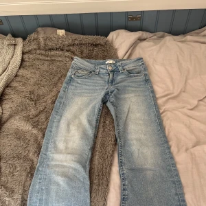 Ljusblå bootcut jeans från Gina Tricot - Säljer ett par ljusblå jeans från Gina Tricot i storlek 164. Modellen har klassisk femficksdesign, knapp och dragkedja fram samt snygg bootcut passform. Jeansen är tillverkade i jeansmaterial och har en cool tvättad look.