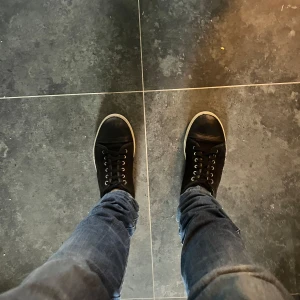 Lanvins - Säljer ett par svarta sneakers från Lanvin med ovandel i mocka och detaljer i skinn. Skorna har rund tå, svarta snören och en vit platt sula. Klassisk och stilren design med diskret branding på insidan. Perfekta till jeans eller andra casual outfits.
