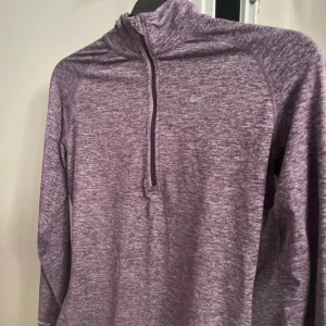 Lila Nike Dri-Fit träningströja - strl S - Sportig lila Nike Dri-Fit träningströja med halv dragkedja och lång ärm. Materialet är lätt, perfekt för löpning eller gym. Sitter skönt och har en modern passform. (pris kan diskuteras) ❣️