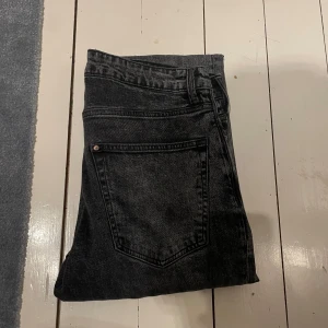 Svarta tapered jeans från H&M 32/32 - Säljer ett par svarta tapered jeans från H&M i storlek 32/32. Jeansen har en klassisk femficksmodell, normal midja och avsmalnande ben. Materialet är denim i bomull och färgen är tvättad svart för en cool look.