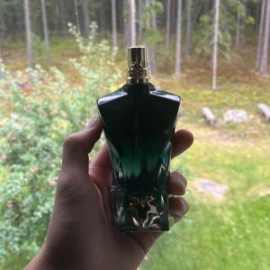 Jean Paul Gaultier Le Beau Parfum 55ml - Säljer en Jean Paul Gaultier Le Beau Le Parfum, ca 55/75ml kvar. Flaskan har en cool grönsvart kroppsliknande form med gulddetaljer och kommer i en snygg grön metallburk med guldtext. Perfekt för dig som gillar unika och lyxiga dofter.
