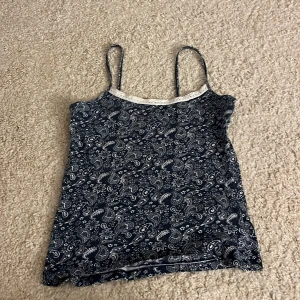 Blå paisleymönstrad linnetopp Love to Lounge - Supersöt blå linnetopp från Love to Lounge med vitt paisleymönster och tunna axelband.😍 stretchigt material så passar upp till 38-40. Men skulle säga att den är 34, det beror på hur tight man vill att den ska sitta💗💗