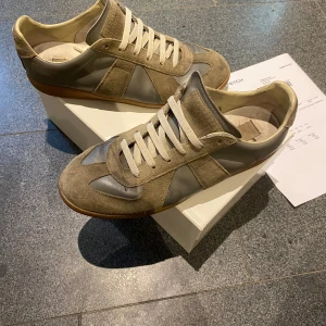 Arme gröna Maison margiela GATs - Grå/armegröna Maison margiela Gats.  Har såklart kvitto. Box, dustbag och kvitto medföljer. Skriv om ni undrar något.