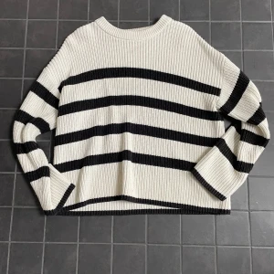 Randig stickad tröja från Selected Femme - Säljer en ribbstickad tröja från Selected Femme i vitt med svarta breda ränder. Tröjan har en relaxed fit, rund halsringning och långa ärmar. 