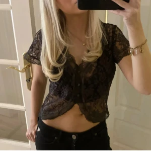 Brun spetsbolero - Säljer en svart, transparent spetsblus med korta ärmar och knappar framtill. Skriv gärna för mer info och bilder, pris går att diskutera