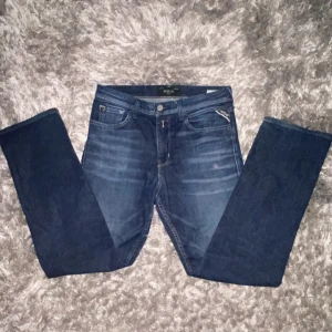 Blå jeansbyxor från Replay - Snygga blå jeans från Replay med diskreta slitningar framtill. Byxorna har raka ben och normal passform, med detaljerade sömmar på bakfickorna och Replay-logga på myntfickan. Perfekta för en avslappnad och stilren look. Kom privat för mer info och pris!💯