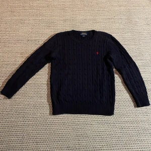 Ralph laurent tröja  - Mörkblå kabelstickad Ralph Lauren tröja. Den är i mycket bra skick utan några defekter. Skriv gärna om du har några frågor. 