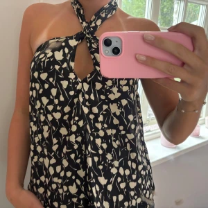 Svart blommig halterneck linnetopp - Halterneck topp med blommönstrer, strl S. Använd få gånger, bra skick! Från Zara