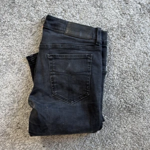 Svarta jeans från tiger of Sweden 30/32 - Snygga svarta jeans från tiger of Sweden , tillverkade i Italien. Klassisk femficksmodell med silverfärgade nitar och knapp, samt diskret tiger of Sweden logga vid fickan. Jeansen har en rak passform och är gjorda i mjukt denimtyg.