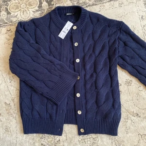 Mörkblå kabelstickad kofta Gina Tricot slutsåld - Chunky kabelstickad kofta från Gina Tricot i mörkblått. Helt slutsåld i butik och Online. Storlek S, ny med prislapp