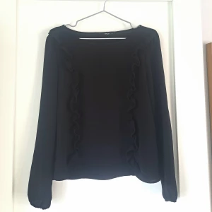 Svart blus med volang från ONLY - Köpt från plick, men är i väldigt bra skick! (Inga synliga defekter). 