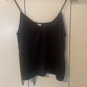 Svart linnetopp från Gina Tricot - Enkel och stilren svart linnetopp från Gina Tricot med tunna axelband. Toppen har rak passform och är perfekt att matcha med jeans eller kjol. Använt några gånger 💞