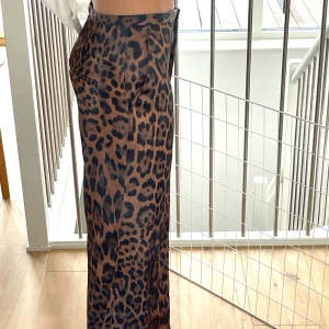 Leopardmönstrade wide byxor H&M - Snygga leopardmönstrade byxor från H&M i storlek 36. Byxorna har mellan-hög midja och ett wide fit med raka, långa ben. Lite glansig känsla! Lite för långa för mig som är 165cm. Men nice till klackar. Köpte på rea då de har lite slitage längst fram! 🐆 me. Endast använda en gång 