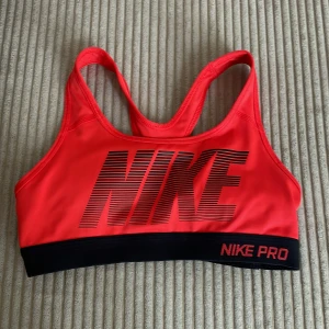 Nike röd sporttopp XS - En röd Nike PRO sporttopp! Lite textilfiber längs ner på kanten (se bild) annars väldigt bra skick. Säljer då dne tyvärr är för liten för mig.