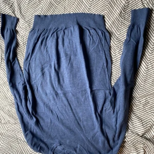 Blå långärmad tröja Dressmann M - Mörkblå långärmad tröja från Dressmann i mjuk bomull. Tröjan har bred ribbad mudd vid hals och ärmslut, klassisk passform och enkel design. Perfekt för dig som gillar stilrena och bekväma plagg.