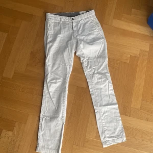 Vita chinos från Emilio, storlek 30 - Snygga vita chinos från Emilio i storlek 30. Byxorna har raka ben, klassiska fickor fram och bak samt bälteshällor. Perfekta för en clean och fräsch look. Materialet känns mjukt och lätt, passar grymt till vår och sommar.