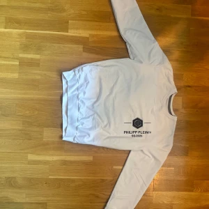 Vit Philipp Plein sweatshirt - Snygg vit sweatshirt från Philipp Plein med svart logga och texten SS-2020 på bröstet. Tröjan har rund halsringning, långa ärmar och ribbade muddar.