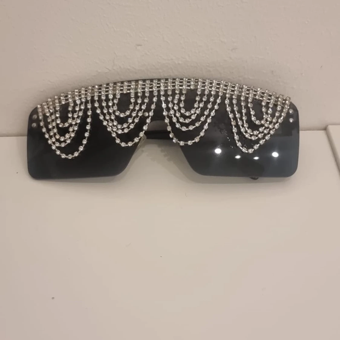 Svarta solglasögon med glittriga kedjor