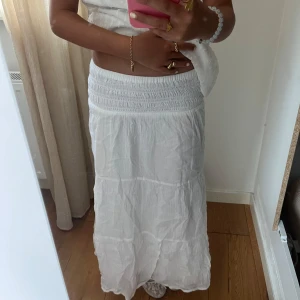 Vit långkjol med smock i midjan - Superskön vit långkjol med smockad midja. säljer för att den inte kommer till användning 
