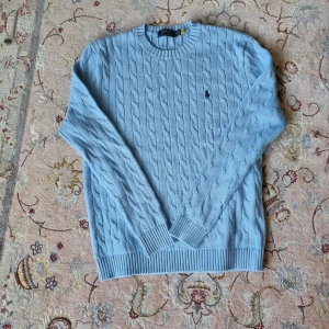 RALPH LAUREN KABELSTICKAD TRÖJA- ljusblå - Säljer nu denna riktigt puliga kabelstickade tröjan i praktiskt taget nyskick i storlek M. . Kontakta gärna vid intresse. 