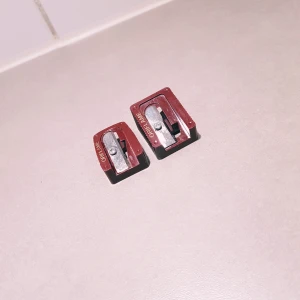 Oriflame pennvässare duo - Två smidiga pennvässare från Oriflame i vinröd och svart plast med metallblad. Perfekta för att vässa både smala och tjocka sminkpennor som läpp- eller ögonpennor. Kompakt design som är lätt att ta med i sminkväskan.  Stora= ca 3 cm & 2,5 cm bred Lilla= ca 3 cm & 2 cm bred Helt & fint skick