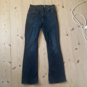 Levi's bootcut jeans blå - Snygga Levi's jeans i mörkblå tvätt med bootcut. Jeansen har fickor fram och bak, normal passform och är tillverkade i slitstarkt denim. Knappt använda och i väldigt fint skick.