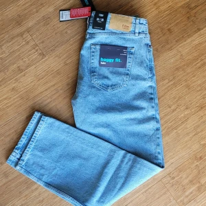 Baggy jeans W30/L30 Nya med prislapp! - Säljer ett par ljusblå jeans inköpta på NewYorker med baggy fit och klassisk femficksdesign. Jeansen har normal midja, raka ben. Se sista bilden för mer korrekt färgupplevelse! Storlek 30/30 Nyskick! Hämtas i Huskvarna vid överenskommelse eller skickas.