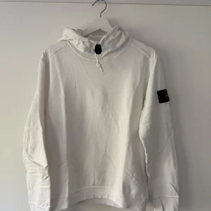 Vit hoodie från Stone Island - Säljer en stilren vit hoodie från Stone Island med klassisk patch på armen och drag detalj. Tunnare hoodie perfekt för sommaren ☀️