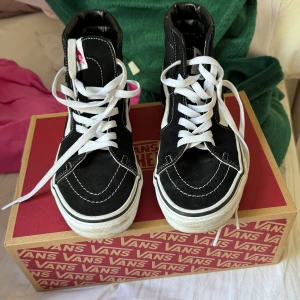 Svarta höga sneakers från Vans - Säljer ett par klassiska svarta Vans sneakers med vit sula och vit sidestripe. Skorna är höga med vit snörning och har tydliga kontrastsömmar. Perfekta för dig som gillar streetstyle och för dig . Den är helt ny och oanvänd , köpte under januari 🩷kartongen medföljer 🩷