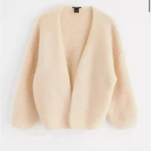 Beige stickad cardigan från Lindex  - Mysig beige stickad cardigan från Lindex med oversized passform och lång ärm. Koftan är öppen framtill utan knäppning och har en fluffig, mjuk känsla. Perfekt för lager-på-lager och enkel att styla till olika outfits.💞💞
