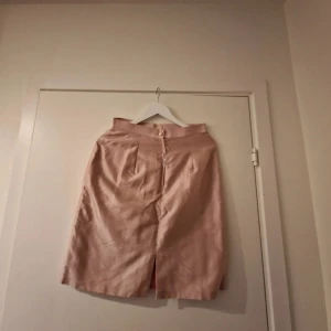 Beiga shorts  - Säljer en beiga shorts med hög midjal. Shortsen har knäppning och dragkedja i midjan och är i en rak modell som slutar strax ovanför knäna. Perfekt för dig som gillar stilrena plagg.