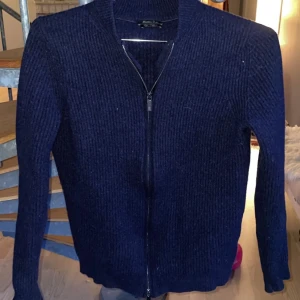 Mörkblå stickad kofta från Massimo Dutti - Mörkblå stickad kofta från Massimo Dutti i ull- och kashmirblandning. Koftan har dragkedja framtill och ribbad struktur, skitnsygg tröja men kommer ej till användning längre, Det är storlek M på tröjan men passar garanterat på S
