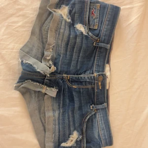 As coola low waist Hollister jeans shorts - Säljer mina älskade Hollister jeans shorts med coola slitningar som ger en 2016 vibe. Skit snygga perfekta nu till sommaren. Skriv om du har några frågor💘💘💘kan såklart sänka priset tar bud, andra bilden är lånad men resten är mina egna