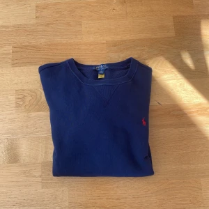 Mörkblå tröja från Ralph Lauren - Mörkblå tröja från Ralph Lauren med rund halsringning och liten röd broderad logga på bröstet, den är i väldigt bra skick och har inga defekter, perfekt för en avslappnad stil. Den är barn strl L / 14-16. Tveka inte att höra av dig vid frågor😃Kan gå ner en del vid snabb affär💸