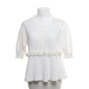 Vit blus med spetsdetaljer - Söt vit blus med spetsdetaljer och volang i midjan. Blusen har korta ärmar och rund halsringning. Perfekt för en fräsch och romantisk look. Skulle säga att den passar dem som har runt s-m. Hör gärna av dig om du har några frågor💕