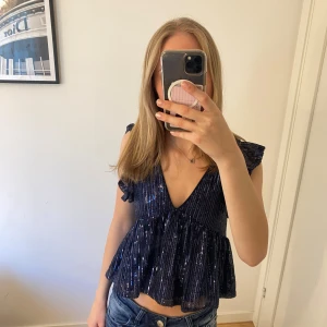 Mörkblå glittrig blus från Nelly - Glittrig fest topp från Nelly. Är i storlek xxs men passar mig som brukar ha xs-s. Är inte använd många gånger och har inga defekter❣️❣️