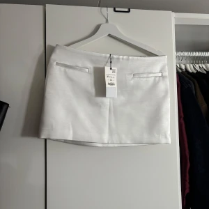 Vit minikjol från Zara - Säljer en vit satin minikjol från Zara med prislapp kvar. Nypris är 399